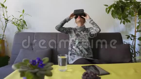 在沙发上享受虚拟现实护目镜的女人视频的预览图