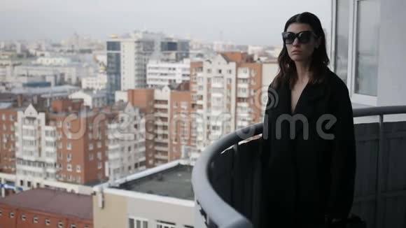 城市背景中阳台上的女人视频的预览图