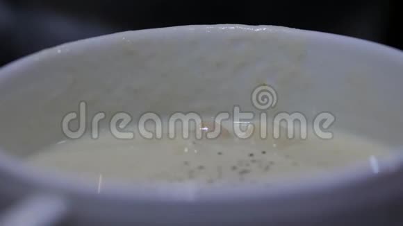 在一个碗里加奶酪汤女孩用勺子搅拌汤4K视频的预览图