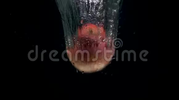 黑色背景下红苹果在水中坠落的录像视频的预览图