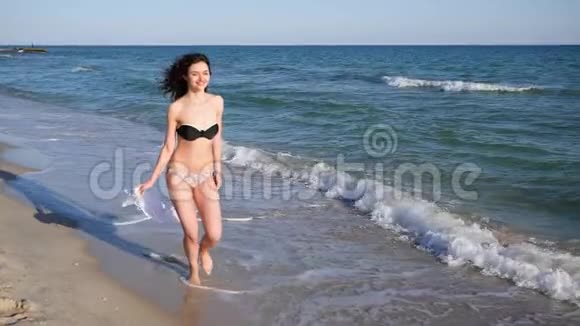 迷人的女性卷发栖息在热带岛屿上年轻美丽的女孩沿着海滩奔跑快乐的女人视频的预览图