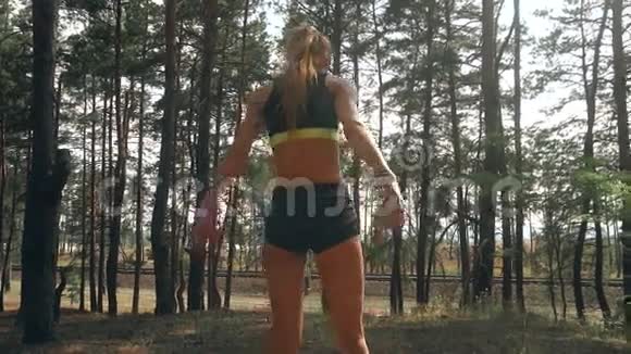 身材苗条的运动女孩穿着短短裤圆屁股在大自然特写镜头上跳跃视频的预览图