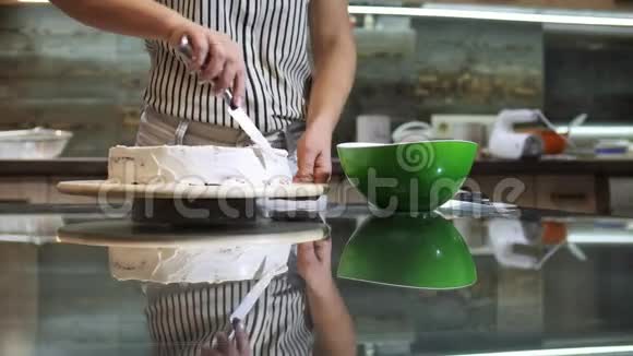 女人用手把奶油放在海绵蛋糕上用手用刀视频的预览图