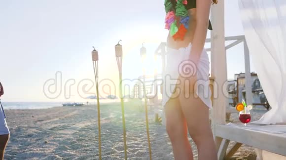 夏威夷派对男邀请穿泳衣的女士在海边跳舞在热带岛屿度蜜月的年轻夫妇视频的预览图