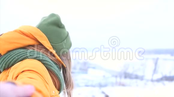 年轻夫妇牵着一双漂亮的金发少女享受冬天的户外活动一个绿色和绿色的女孩视频的预览图