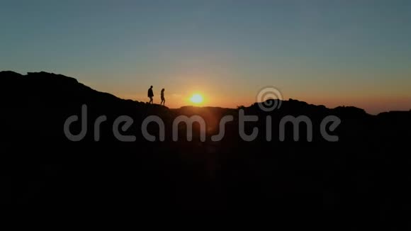 一对夫妇在山顶或日落时散步视频的预览图