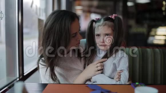 母亲抚慰和拥抱哭泣的女婴美丽的年轻母亲安抚哭泣的女儿视频的预览图