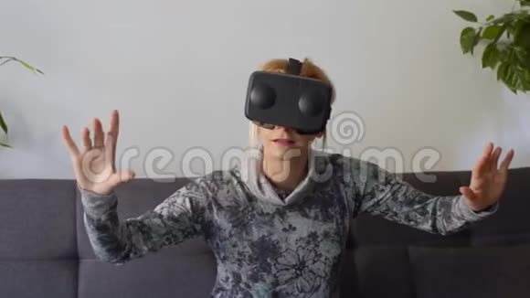 在沙发上享受虚拟现实护目镜的女人视频的预览图