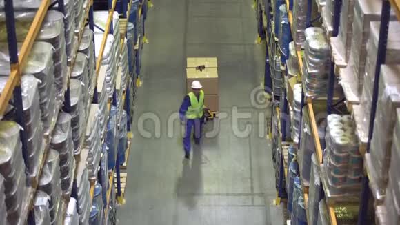 仓库工人在货架间行走搬运货物视频的预览图