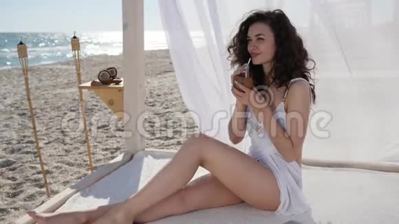 女饮料鸡尾吸管平房N白布风发热带海滩背景视频的预览图