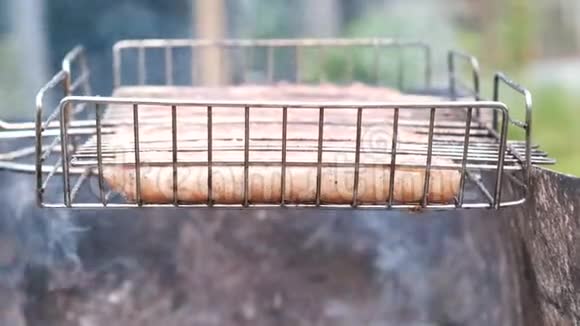 烤架上的香肠用木炭烤侧视视频的预览图