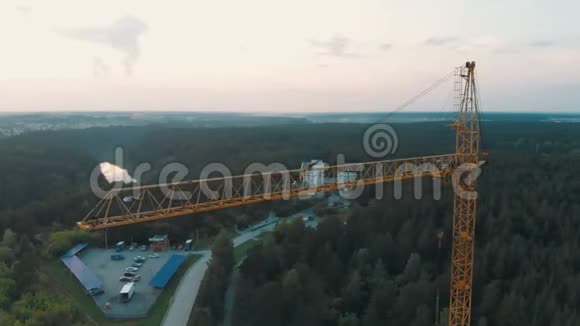高空拍摄鸟瞰黄色塔式起重机在建筑工地建筑公寓房地产周围飞行视频的预览图