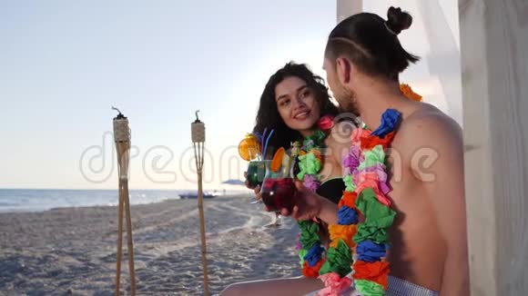 快乐的朋友在海洋海岸喝鸡尾酒美丽的夫妇从夏威夷勒伊的脖子到夏威夷群岛视频的预览图