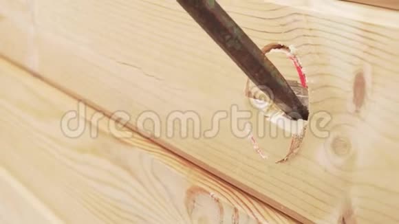带有插座喷嘴的电钻在木墙上留下一个洞视频的预览图