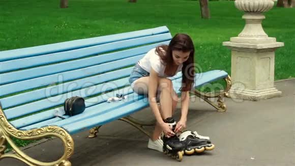 年轻可爱的女孩在溜冰鞋上系鞋带视频的预览图