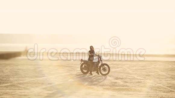 迷人的年轻女子摩托车手和他的女朋友骑摩托车在沙漠日落或日出女朋友骑自行车视频的预览图
