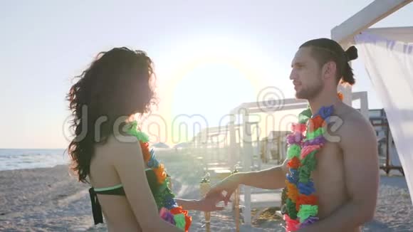 在海边的夏季派对上男人和女孩背光相爱的夫妇在海滩上跳舞浪漫的关系视频的预览图