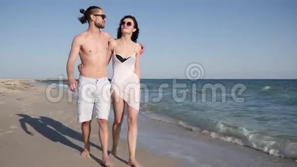 男人抱着女孩夏天相爱光着脚走在沙滩上风发异国情调的假期视频的预览图