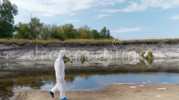 一个穿着防护服和呼吸器的人沿着干河散步视频的预览图