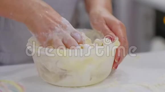 女人手捏面团祖母在桌子上用面粉揉面动作缓慢小麦自制面包双手视频的预览图