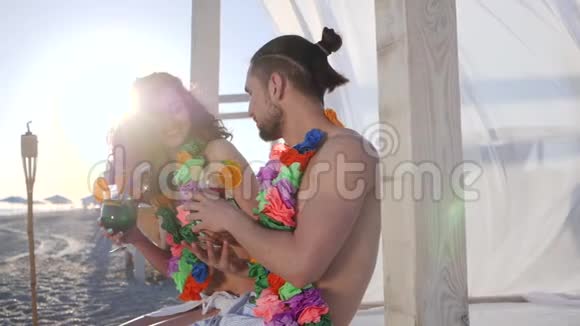 斯迈利女孩在海滩上给男人手里的鸡尾酒在热带岛屿上的暑假快乐的男人和女人到异国情调视频的预览图