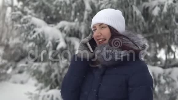 在清新的空气中行走在冬林打电话的年轻女子视频的预览图