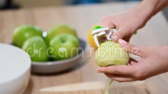女人剥青苹果做水果沙拉家庭主妇做苹果派厨房花园里新鲜健康的食物视频的预览图