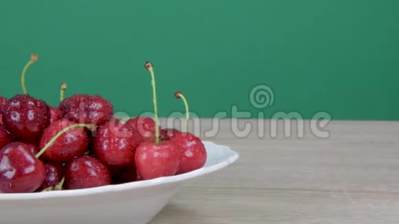 成熟的红樱桃樱桃上的水滴绿色背景滑块镜头视频的预览图