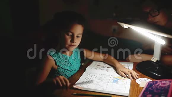 小女孩晚上做家庭作业读一本书和作家晚上做家庭作业女孩课从视频的预览图
