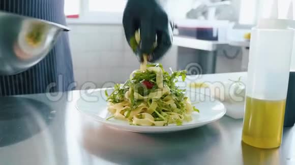 专业厨师从钢碗里手把沙拉放在盘子上视频的预览图