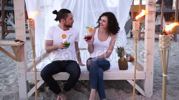 在海滩上休息情侣手里拿着鸡尾酒男女混合饮料朋友在热带喝鸡尾酒视频的预览图