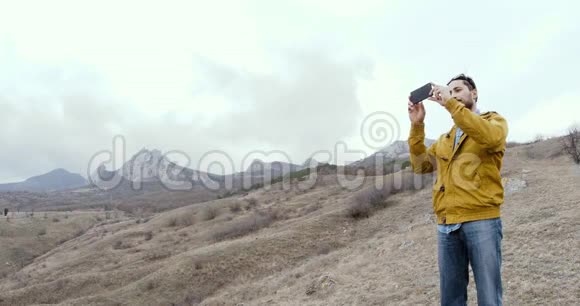 人在移动拍摄而站在山岩背景下视频的预览图