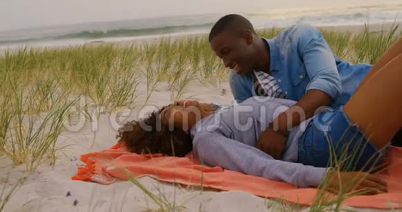 在海滩上玩得开心的非裔美国人夫妇的侧面景色视频的预览图
