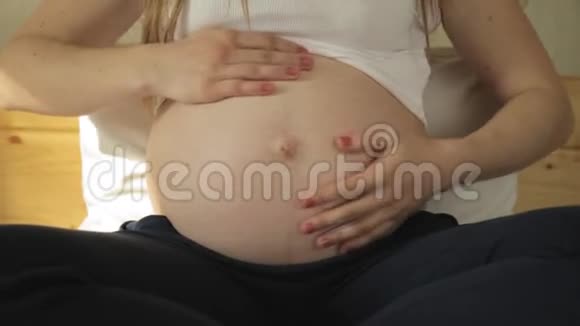怀孕的金发女人绕着肚子抚摸母子关系视频的预览图