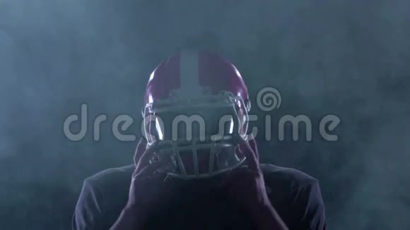 足球在烟雾中把他的头盔从头上移开慢动作视频的预览图