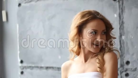年轻的卷发女子在镜头前摆姿势视频的预览图
