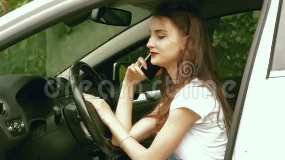 迷人的女士一边开车一边打电话视频的预览图