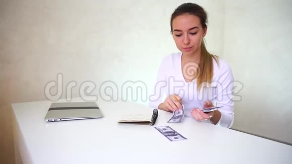 年轻的程序员坐在桌旁手提电脑重新计算月收入视频的预览图