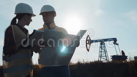 一个团队工程师讨论了一个油泵场的维护在炼油厂工作的工程队两名工人视频的预览图