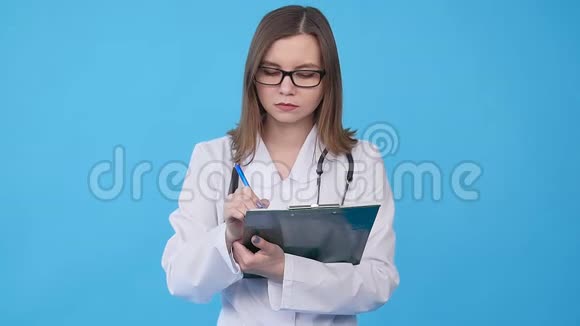 年轻的女医生穿着白色外套带着剪贴板视频的预览图