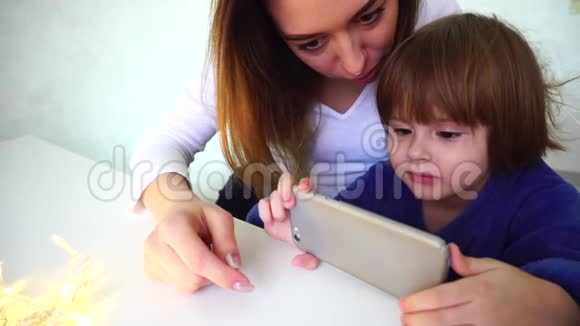 母亲和女儿用智能手机看新年动画片视频的预览图