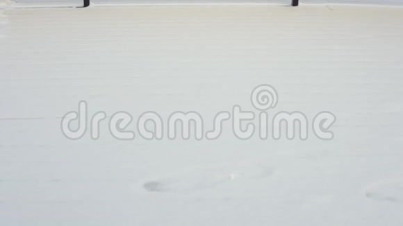 一个穿着暖和的衣服的孩子走过雪地他的脚留下了痕迹视频的预览图