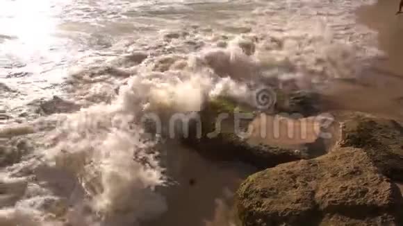 阳光明媚的一天海水在岩石上破裂视频的预览图