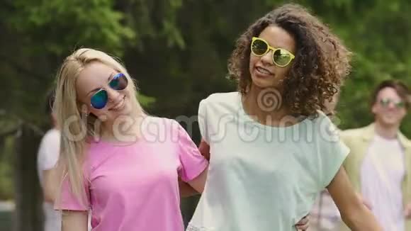 两个女孩拥抱和朋友在聚会上跳舞年轻人玩夏天的乐趣视频的预览图