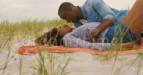 在海滩上玩得开心的非裔美国人夫妇的侧面景色视频的预览图