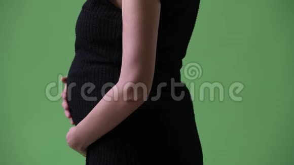绿色背景下年轻美丽的怀孕女商人的形象视频的预览图