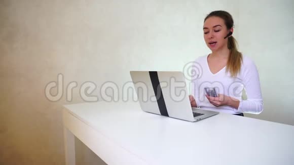 年轻女孩坐在笔记本电脑附近为哥哥谈论礼物视频的预览图