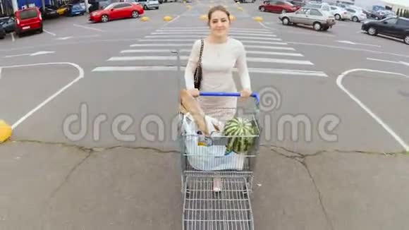 一位年轻漂亮的女士带着满满的购物车从超市走出来视频的预览图
