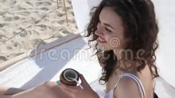 夏季度假胜地的女性休息可爱的女孩在海边休息时欢笑女人喝鸡尾酒视频的预览图