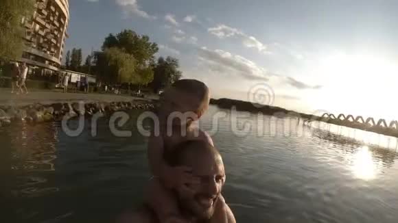 快乐的父亲和儿子一起在海滩上自拍微笑视频的预览图